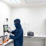 Onderzoeker in beschermend pak werkt met laboratoriumapparatuur