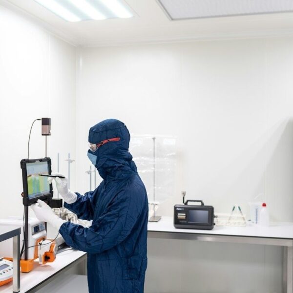 Onderzoeker in beschermend pak werkt met laboratoriumapparatuur