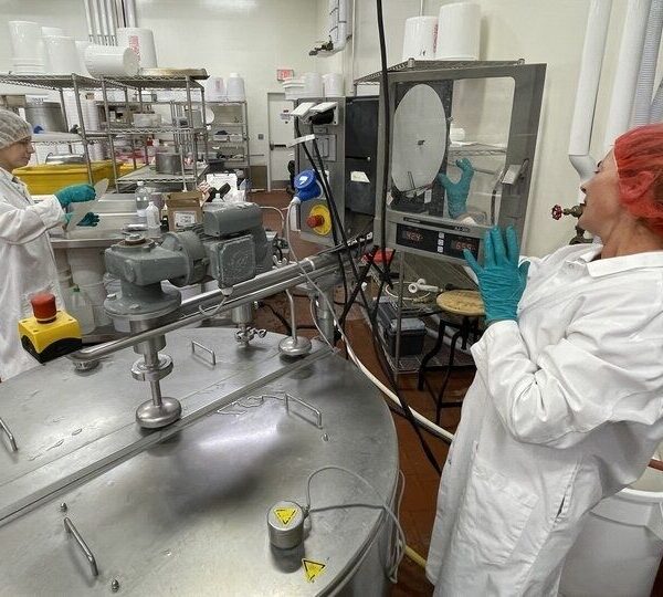 Laboratoriummedewerkers bij roestvrijstalen apparatuur voor kaasproductie