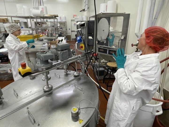 Laboratoriummedewerkers bij roestvrijstalen apparatuur voor kaasproductie