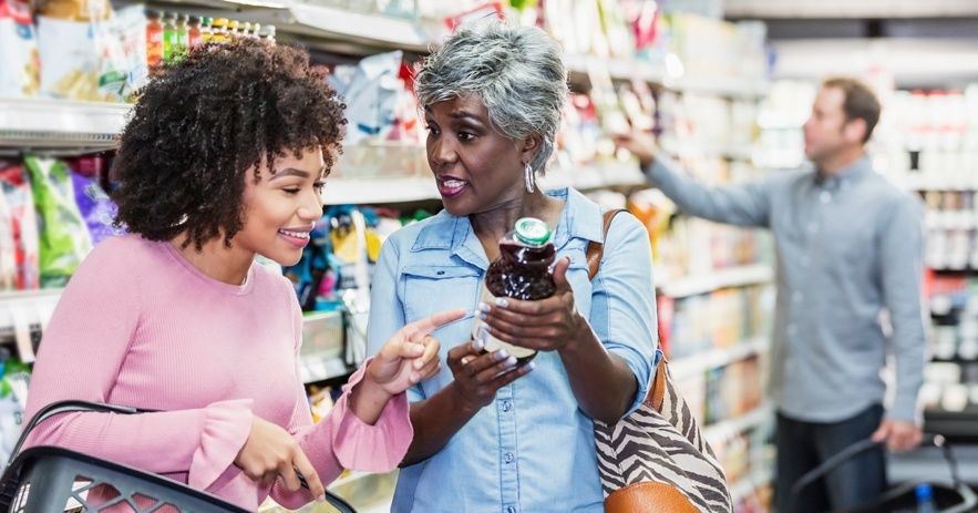 Twee vrouwen bekijken samen een voedingsproduct in een supermarkt